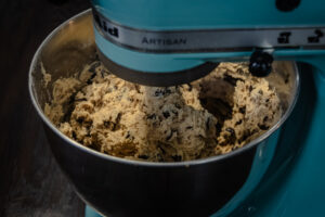 Fully mixed chocolate chip cookie dough in a stand mixer