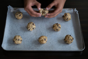 A person breaking cookie dough balls apart