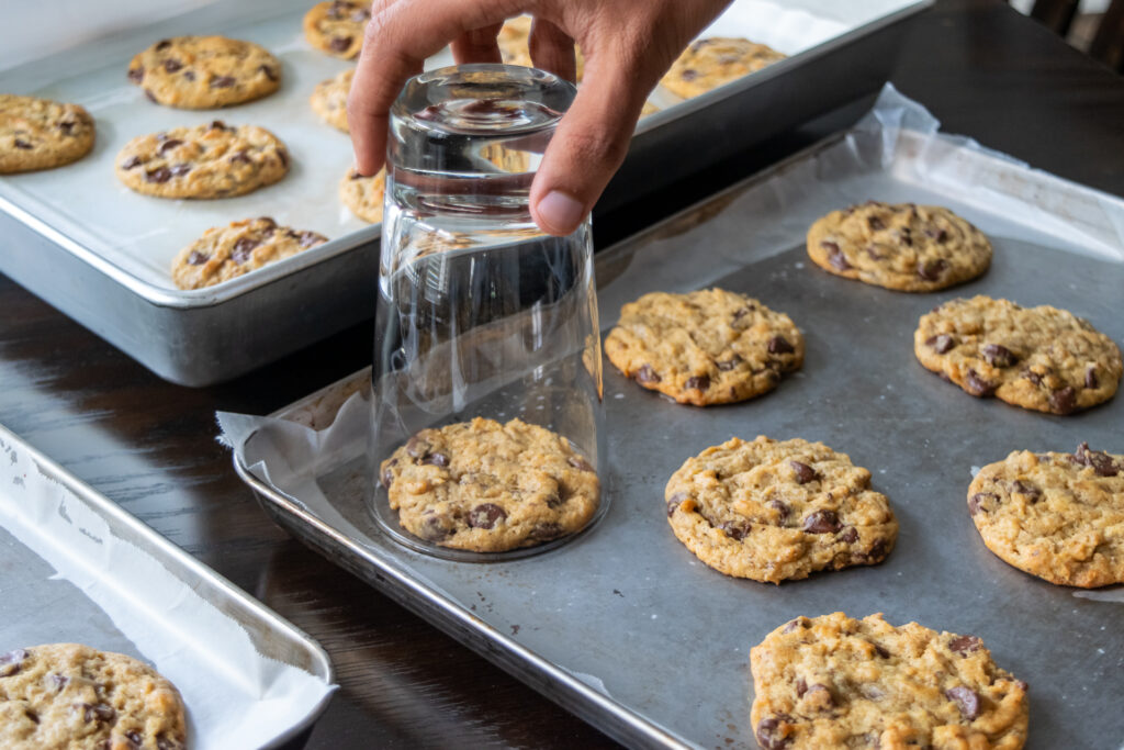 Swirling a glass around cookies to shape them.
