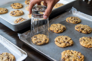 Swirling a glass around cookies to shape them.
