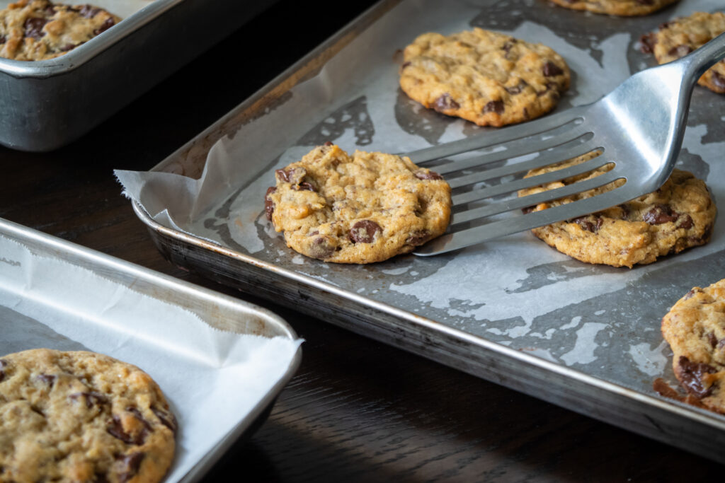 Lifting cookies off a sheet tray with a spatula